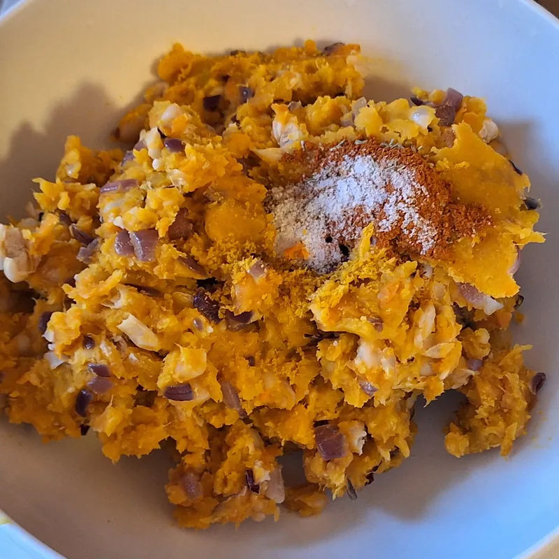 The mixture in a bowl with spices and aromatics, ready to be blended.