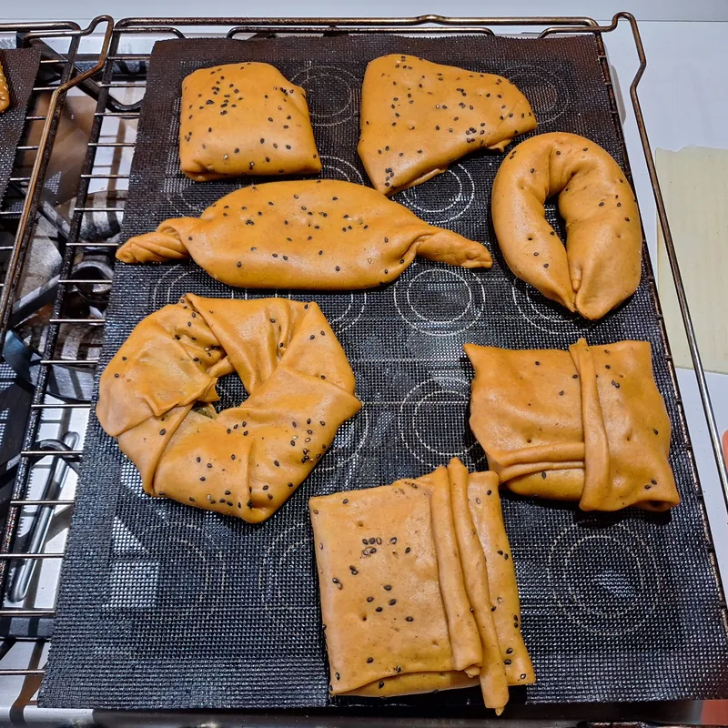 I tortini ai pomodori secchi e paprika chiusi, decorati con semi di sesamo nero, pronti da infornare