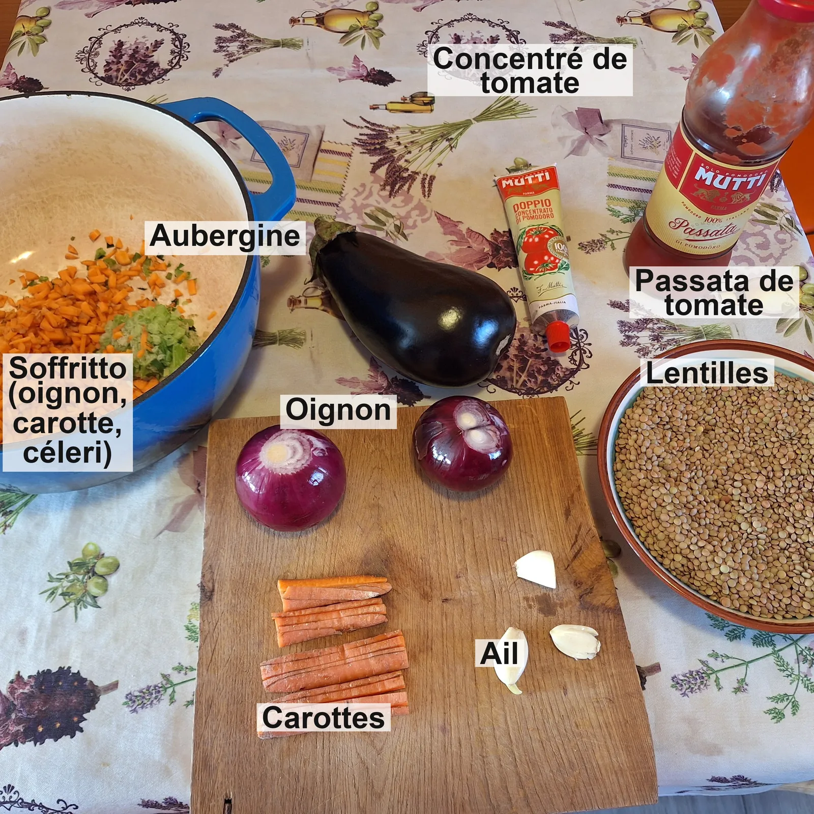 Les ingrédients étiquetés : le soffritto d'oignon, carotte et céleri dans la casserole, aubergine, concentré de tomate, passata, oignon, carottes, ail et lentilles.